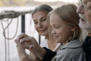 girl in gray long sleeve shirt smiling with her grandparents
